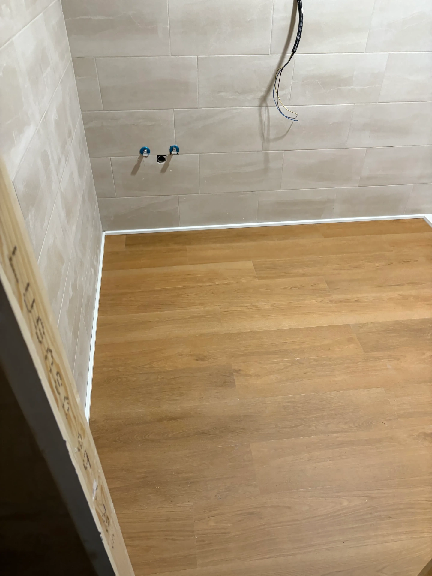 Suelo de madera instalado en baño con alicatado claro