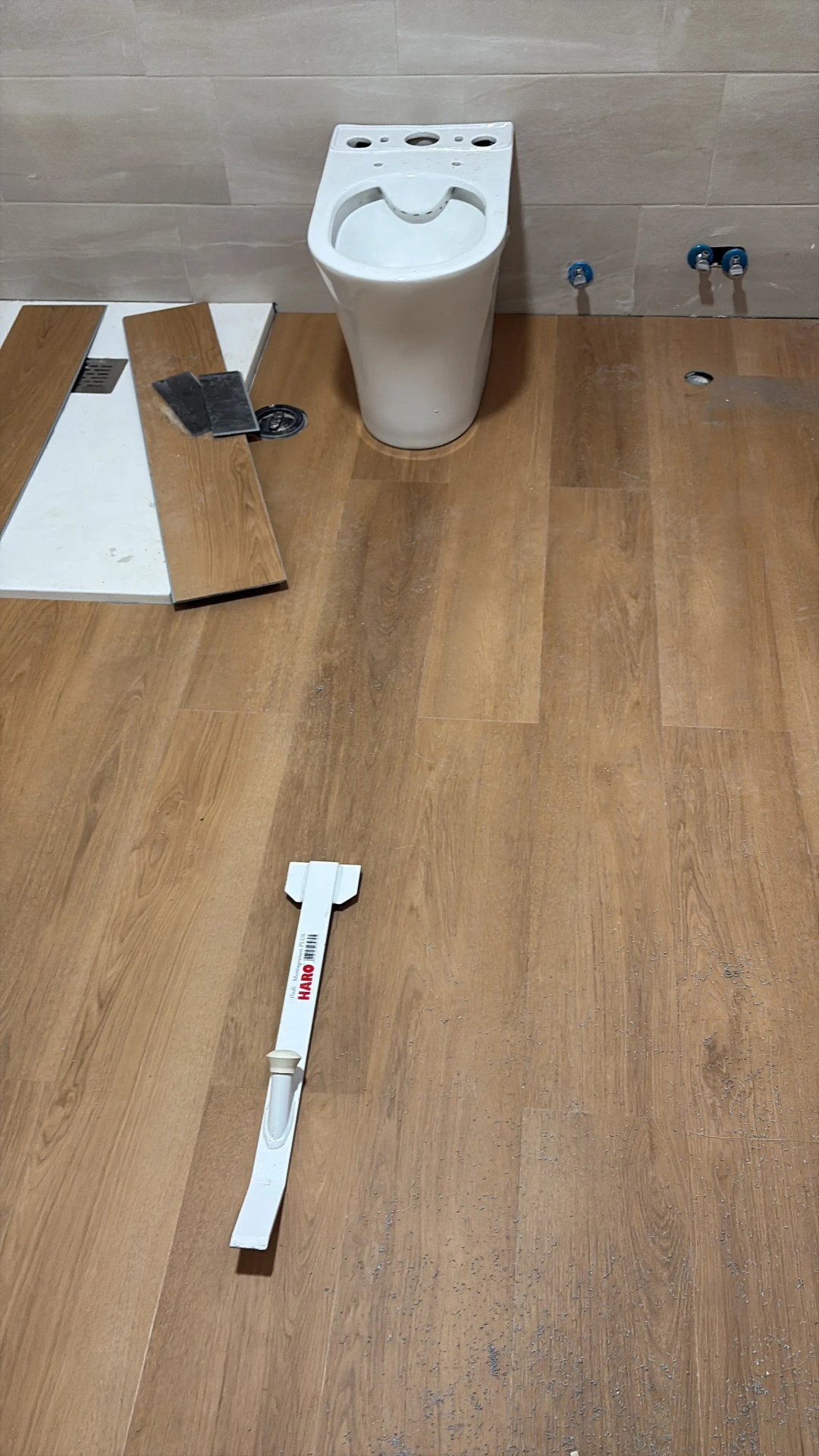 Suelo de tarima de madera en baño con inodoro suspendido
